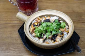 A rice dish in a bowl topped with mushrooms and herbs